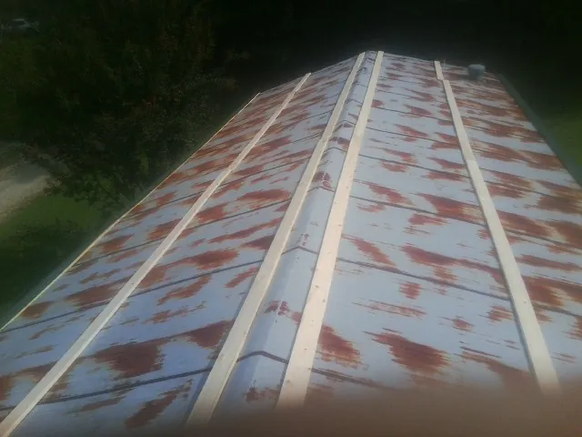 Rusted metal roof panels with new wood purlins before replacement — Storm Damage Roof Repair in Whitharral by Roofing Brothers
