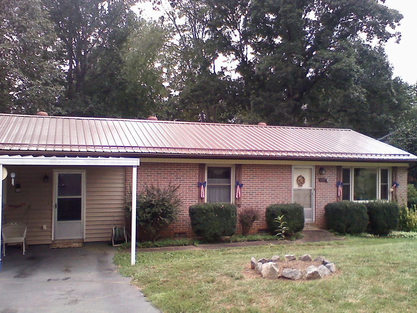 Bronze metal roof and carport on a brick ranch home — Roof Repair work by our crew in Whitharral